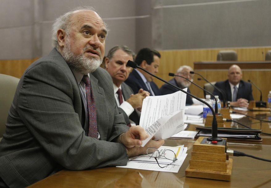 FILE - In this July 10, 2013 file photo Commissioner Mike Florio, of the California Public Utilities Commission, left, talks during an informational hearing at the Capitol in Sacramento, Calif. Big energy users are set to get a break on electricity while more efficient consumers will see their bills rise under a proposal being considered by California regulators. The state Public Utilities Commission is scheduled to vote Friday, July 3, 2015, on an overhaul of the way the state's investor-owned utilities charge for electricity, the first such reform since brownouts roiled the state 15 years ago. (AP Photo/Rich Pedroncelli, File)