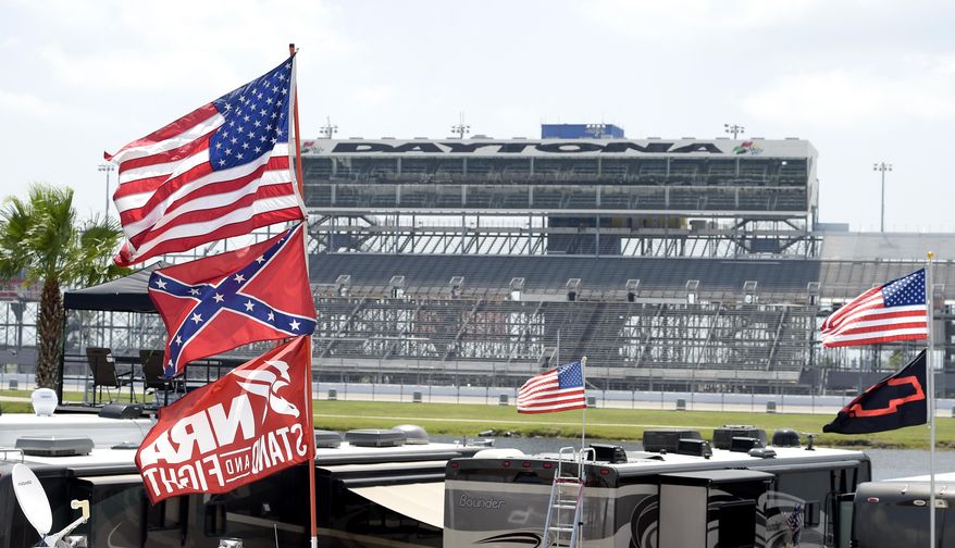 Confederate and American flags fly on top of motor homes at Daytona International Speedway, Saturday, July 4, 2015, in Daytona Beach, Fla. NASCAR and the speedway offered to replace any flag a race brings to the track with an American flag. (AP Photo/Phelan M. Ebenhack)
