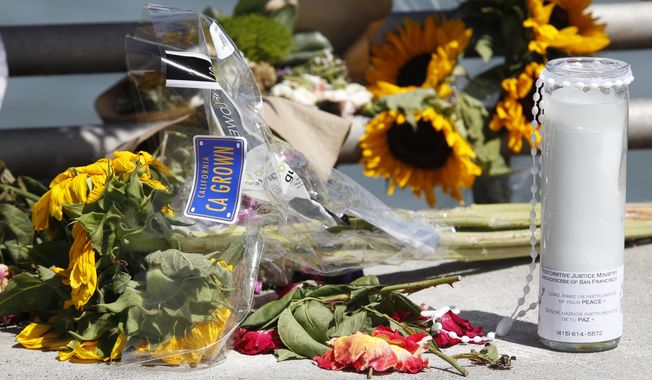 Flowers and a candle lay on the ground following a vigil for Kathryn Steinle, Monday, July 6, 2015, on Pier 14 in San Francisco. Steinle was gunned down while out for an evening stroll at Pier 14 with her father and a family friend on Wednesday, July 1. (AP Photo/Beck Diefenbach)