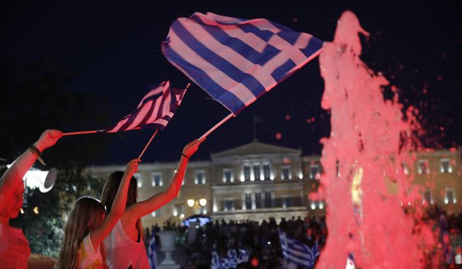 Young girls wave Greek flags as supporters of the No vote react after the first results of the referendum at Syntagma square in Athens, Sunday, July 5, 2015. Greece faced an uncharted future as its interior ministry predicted Sunday that more than 60 percent of voters in a hastily called referendum had rejected creditors&#x27; demands for more austerity in exchange for rescue loans. (AP Photo/Petros Giannakouris)