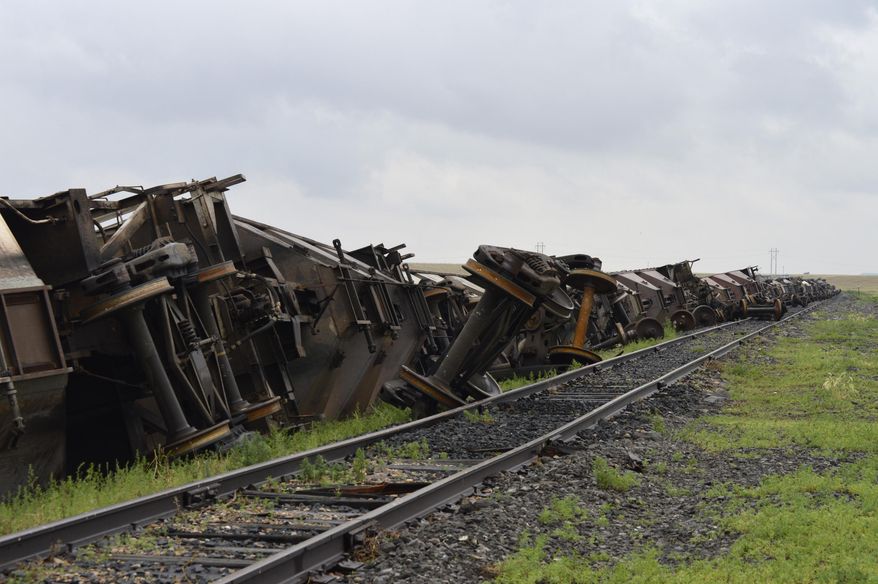 In this Sunday, July 5, 2015, photo, more than 10 empty BNSF Railway cars lie on the ground after they were blown on their sides south of Havre, Mont., during a strong storm that moved across the northern part of Montana on Saturday. Straight-line winds blew at speeds of up to 90 mph and hail as large as ping pong balls fell on Saturday night, uprooting trees, flattening crops, damaging buildings and breaking windows, the National Weather Service said. (Amber Wells/Havre Daily News via AP) MANDATORY CREDIT