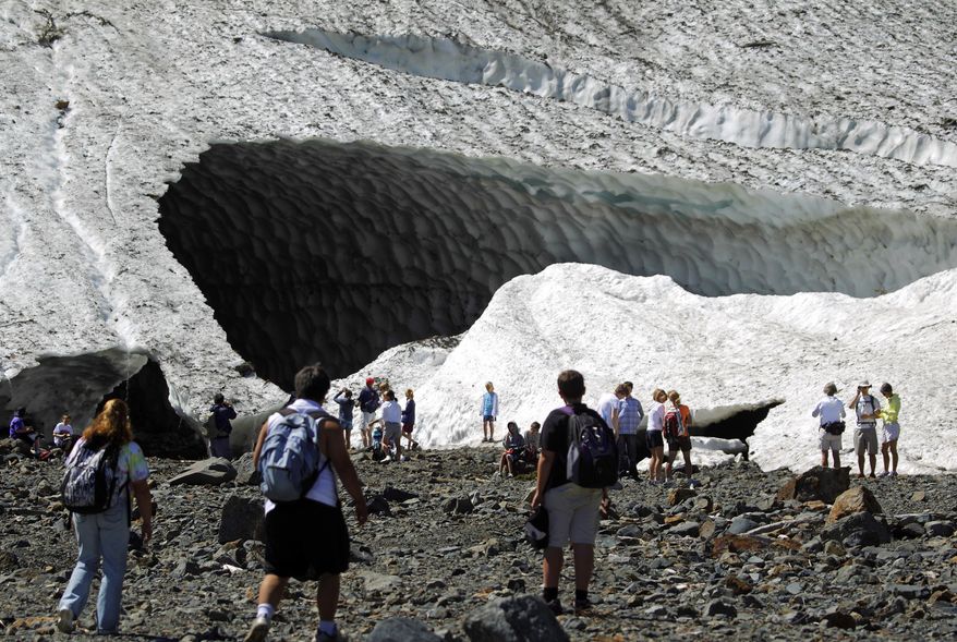 In this July 2010 photo, visitors examine the Big Four Ice Caves in the Mount Baker-Snoqualmie National Forest near Granite Falls, Wash. The Snohomish County sheriff's office says rescuers responded to a report of a partial collapse of the ice caves Monday, July 6, 2015. (Mark Mulligan/The Herald via AP)
