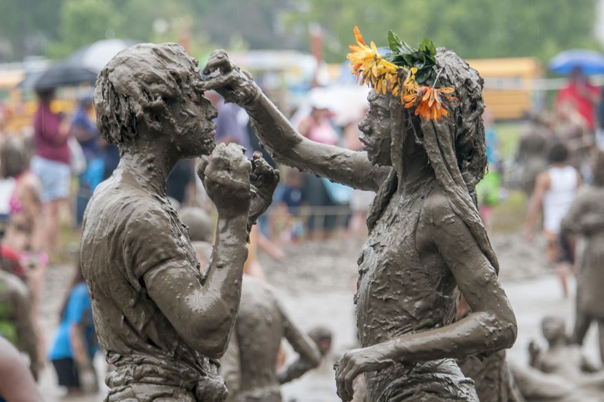 Caprise Debose, left, and Kaliyah Watson, of Westland, play together during the annual Mud Day at Nankin Mills Park in Westland, Mich. on Tuesday, July 7, 2015. (David Guralnick/The Detroit News via AP) DETROIT FREE PRESS OUT - HUFFINGTON POST OUT - NO MAGS - NO SALES- NO ARCHIVE - MANDATORY CREDIT