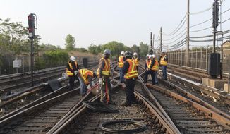 In this May 27, 2015, file photo provided by the Metropolitan Transit Authority, workers repair a section of cable that was severed by vandals who stole 500 feet of copper cable from train tracks along the A train subway line south of Howard Beach, in the Queens borough of New York. (Metropolitan Transit Authority, Marc A. Hermann via AP, File)