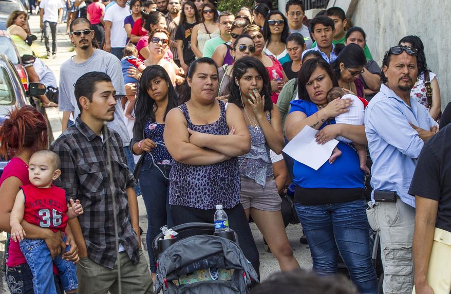 FILE - In this Aug. 15, 2012, file photo, a line of people living in the U.S. without legal permission wait outside the Coalition for Humane Immigrant Rights in Los Angeles. According to figures released in late June, 2015, by the U.S. Census Bureau, Hispanic Californians began to narrowly outnumber white Californians sometime in the first half of 2014. (AP Photo/Damian Dovarganes, File)
