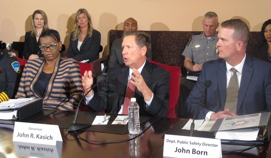 FILE - In this April 29, 2015, file photo, Ohio Gov. John Kasich, center, announces a plan for first-ever statewide police standards for the proper use of force, recruiting and hiring in Columbus, Ohio. Former state Sen. Nina Turner, left, and state public safety director John Born, right, both played roles in the standards' creation. The board, created by Kasich in April, meets for the first time Wednesday, July 8. (AP Photo/Andrew Welsh-Huggins, File)