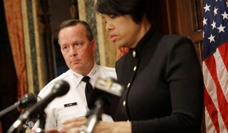 Interim Baltimore Police Department Commissioner Kevin Davis, left, follows Baltimore Mayor Stephanie Rawlings-Blake into a news conference, Wednesday, July 8, 2015, in Baltimore, to announce her firing of Commissioner Anthony Batts. (AP Photo/Patrick Semansky)