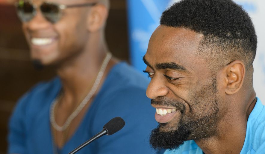 Asafa Powell, from Jamaica, left, and Tyson Gay, from the USA, right,  attend a news conference on the eve of the Athletissima international Athletics meeting, in Lausanne, Switzerland, Wednesday, July 8, 2015. ( (Jean-Christophe Bottt/Keystone via AP)