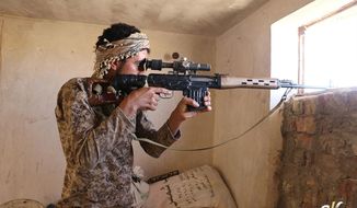 In this photo released on June 23, 2015, by a website of Islamic State militants, an Islamic State militant looks through the scope of his rifle in Kirkuk, northern Iraq. Though best known for its horrific brutalities — from its grotesque killings of captives to enslavement of women — the Islamic State group has proved to be a highly organized and flexible fighting force, according to senior Iraqi military and intelligence officials and Syrian Kurdish commanders on the front lines. (Militant website via AP)