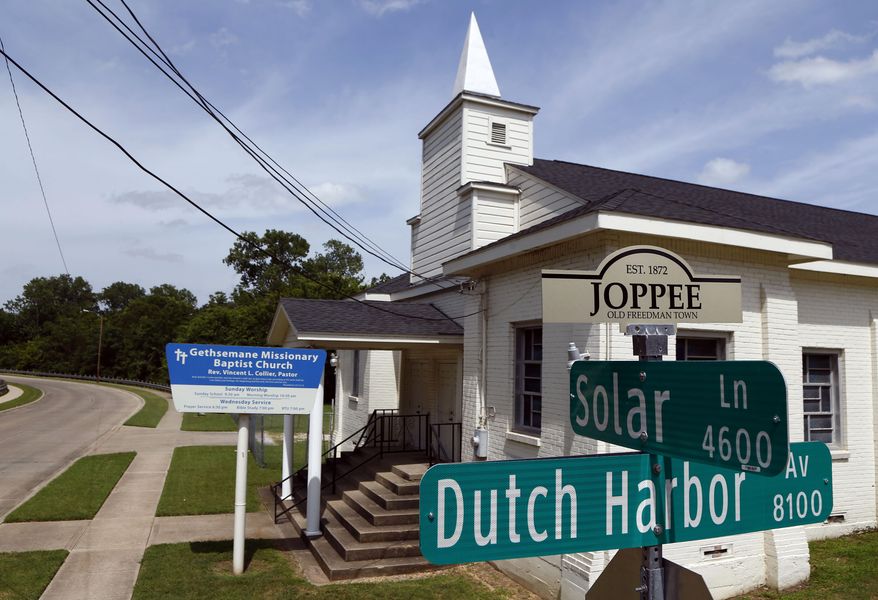 In this Thursday, July 2, 2015 photo, the Gethsemane Missionary Baptist Church is seen behind the Joppee Old Freedman Town historical marker in Dallas. As neighborhood residents push for historical recognition and hope for future development, the spelling difference of Joppee and Joppa have become a divisive issue. (Nathan Hunsinger/The Dallas Morning News via AP)