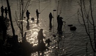People fish in a stream outside a steel factory in the Sea of Azov port city, Mariupol, Ukraine, Tuesday, March 10, 2015. The bulk of continued unrest along the 485-kilometer (300-mile) front lines, between Ukraine&#39;s government forces and Russia-backed rebels, has been concentrated around the separatist stronghold of Donetsk, but pitched battles are also taking place in the town of Shyrokyne, near the strategic port city of Mariupol. (AP Photo/Vadim Ghirda)