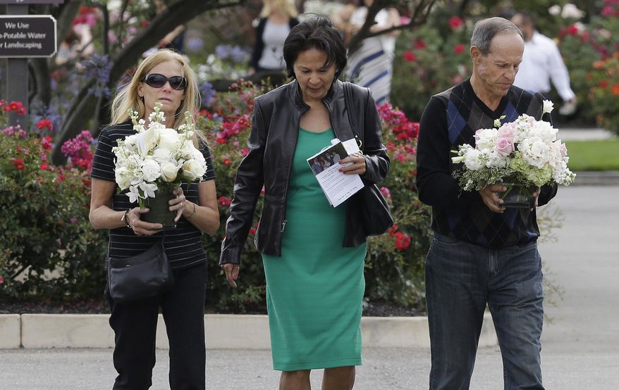 Two women and a man walk toward the parking lot after a memorial service for Kathryn Steinle in Pleasanton, Calif., Thursday, July 9, 2015. Steinle, of San Francisco, was gunned down by Juan Francisco Lopez Sanchez on July 1 while walking along a city pier with her father. (AP Photo/Jeff Chiu)