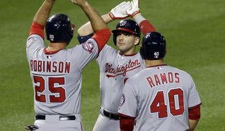 Washington Nationals&#39; Danny Espinosa, center, high-fives teammates Clint Robinson, left, and Wilson Ramos after batting them in on a home run in the sixth inning of an interleague baseball game against the Baltimore Orioles, Saturday, July 11, 2015, in Baltimore. (AP Photo/Patrick Semansky)