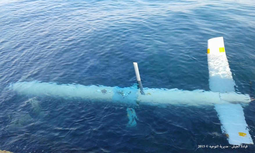 In this photo released by the Lebanese Army official website, an Israeli drone is seen under the water in the port of Tripoli, northern Lebanon, Saturday, July 11, 2015. In a statement, the army says the unmanned reconnaissance aircraft crashed Saturday morning. It published photos that showed the aircraft largely intact in the waters and then on land after it was taken out. Arabic writing reads, &amp;quot;Army public affairs.&amp;quot; (Lebanese Army Website via AP)