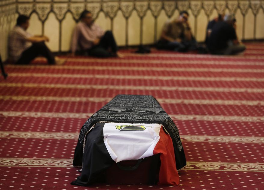 Mourners sit next to the coffin of Egyptian actor Omar Sharif during his funeral procession at the Hussein Tantawi Mosque in Cairo, Egypt, Sunday, July 12, 2015. Sharif, the Egyptian-born actor with the dark, soulful eyes who soared to international stardom in movie epics, "Lawrence of Arabia" and "Doctor Zhivago," died in a Cairo hospital of a heart attack, on Friday, July 10. He was 83. (AP Photo/Hassan Ammar)