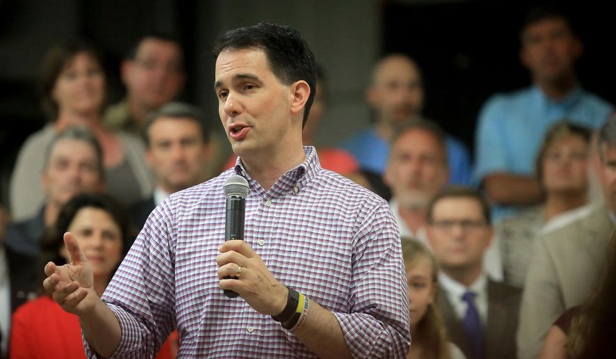 Wisconsin Gov. Scott Walker addresses employees and members of the media at Valveworks USA prior to signing the state&#39;s 2015-2017 budget on the production floor of the Waukesha, Wis. company Sunday, July 12, 2015. (John Hart/Wisconsin State Journal via AP)