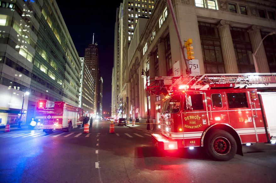 Police and fire trucks blocked off several intersections near the 100 block of West Fort after a suspicious newspaper box was left outside a building housing the offices of the Detroit Free Press and The Detroit News on Sunday, July 12, 2015 in Detroit. Police say the box posed no threat and the building was reopened after being evacuated earlier. (David Guralnick/Detroit News via AP) DETROIT FREE PRESS OUT; HUFFINGTON POST OUT