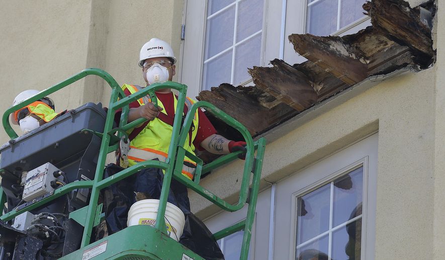 FILE - In this June 18, 2015 file photo a crew works on the remaining wood of an apartment building balcony that collapsed killing six college students and injuring several others in Berkeley, Calif. State Sens. Loni Hancock, D-Berkeley and Jerry Hill, D-San Mateo, have introduced legislation that would require construction companies to disclose felony convictions or legal settlements alleging construction defects to state regulators. The bill, SB465, comes in response to an apartment building balcony collapse in Berkeley, that killed six young people in June. (AP Photo/Jeff Chiu, File)