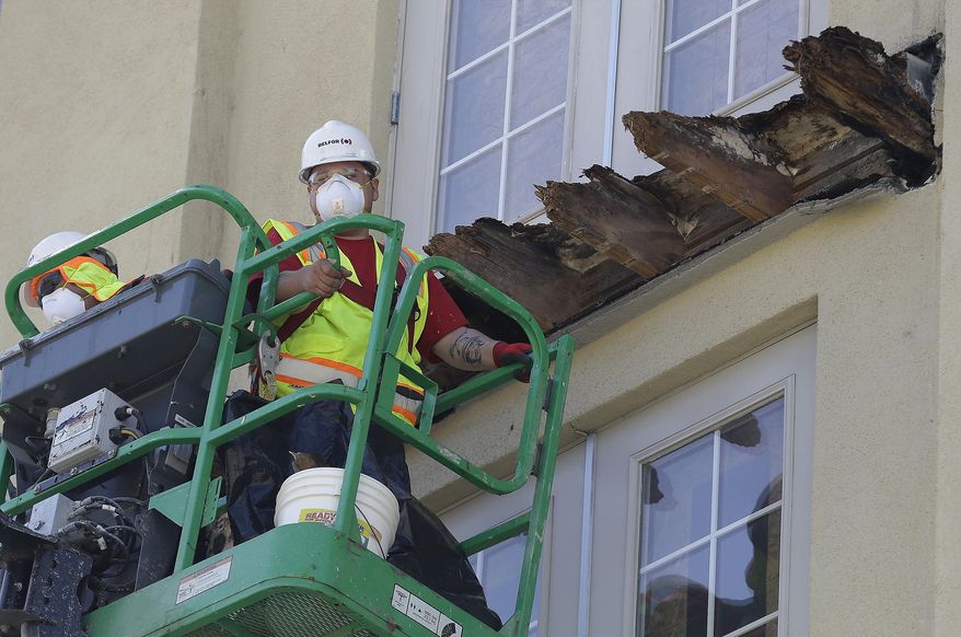 FILE - In this June 18, 2015 file photo a crew works on the remaining wood of an apartment building balcony that collapsed killing six college students and injuring several others in Berkeley, Calif. State Sens. Loni Hancock, D-Berkeley and Jerry Hill, D-San Mateo, have introduced legislation that would require construction companies to disclose felony convictions or legal settlements alleging construction defects to state regulators. The bill, SB465, comes in response to an apartment building balcony collapse in Berkeley, that killed six young people in June. (AP Photo/Jeff Chiu, File)