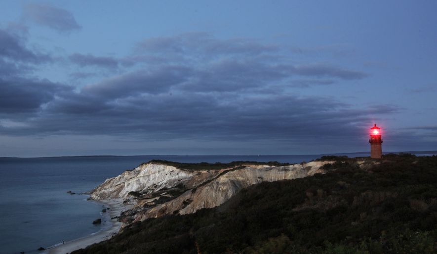 Gay Head Light flashes a red signal in Aquinnah, MA, Oct. 13, 2013 on the island of Martha's Vineyard. The lighthouse flashes alternating red and white beams of light. (AP Photo/Mark Lennihan)