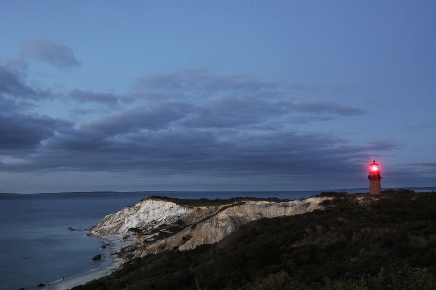 Gay Head Light flashes a red signal in Aquinnah, MA, Oct. 13, 2013 on the island of Martha's Vineyard. The lighthouse flashes alternating red and white beams of light. (AP Photo/Mark Lennihan)