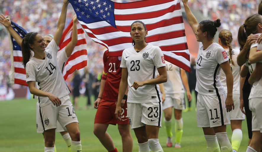 FILE - In this Sunday, July 5, 2015 file photo, United States&#39; Morgan Brian (14), Christen Press (23), and Ali Krieger (11), celebrate with the U.S. flag after the U.S. beat Japan 5-2 in the FIFA Women&#39;s World Cup soccer championship in Vancouver, British Columbia, Canada. The “Kids’ Choice Sports 2015,” airing 8 p.m. EDT Thursday, July 16, will be hosted by NFL player Russell Wilson and include members of the World Cup-winning U.S. women’s soccer team.  (AP Photo/Elaine Thompson, File)