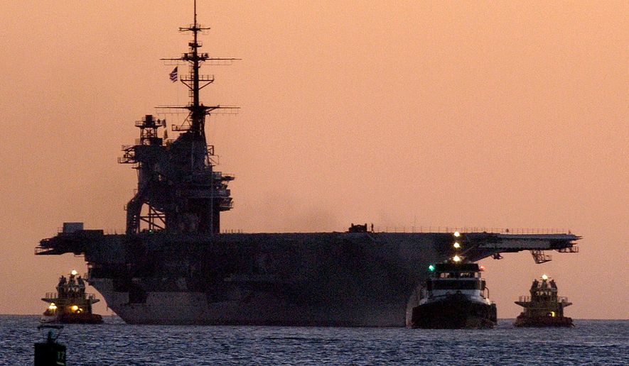 FILE - In this Jan. 5, 2004 file photo, tugboats pull the USS Midway to Navy Pier in San Diego Bay. Authorities say crews have doused a small, smoky fire aboard the USS Midway Museum that prompted evacuation of the historic aircraft carrier in San Diego. City Fire-Rescue spokesman Lee Swanson says the blaze was reported around 5:30 a.m. Wednesday, July 15, 2015, two levels below the flight deck. (AP Photo/Denis Poroy,File)