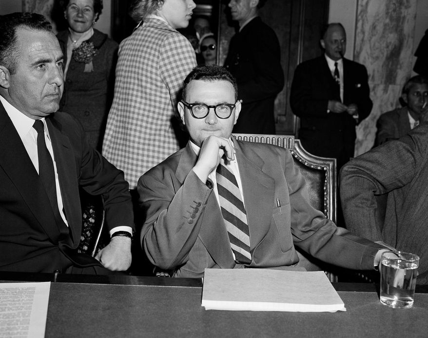 FILE - In this April 26, 1956 file photo, David Greenglass, convicted atomic spy, sits beside Deputy U.S. Marshal Joseph Oreto during a Senate Internal Security on Capitol Hill in Washington. The subcommittee hearing is listening to testimony on the use of Americans for Soviet intelligence purposes. The federal government has unsealed new grand jury testimony in the sensational Cold War spying case of Julius and Ethel Rosenberg. The couple was executed in 1953 after being convicted in New York of conspiring to give atomic secrets to the Soviets. The previously sealed testimony is from Greenglass, the brother of Ethel Rosenberg and the government’s star witness in the trial. (AP Photo/Henry Griffin)