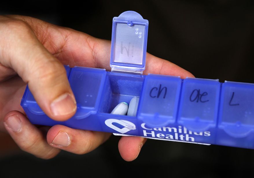 ADVANCE FOR THE WEEKEND OF JULY 18-19 AND THEREAFTER - In a Tuesday, July 7, 2015 photo, Adrian Mesa, psychiatric advance registered nurse practitioner, holds his pillbox filled with medication for homeless clients. For over six months, a team of four headed out into the streets of downtown Miami area to serve medical and psychiatric treatments to the chronic homelessness clients. (Carl Juste/The Miami Herald via AP) MAGS OUT; MANDATORY CREDIT