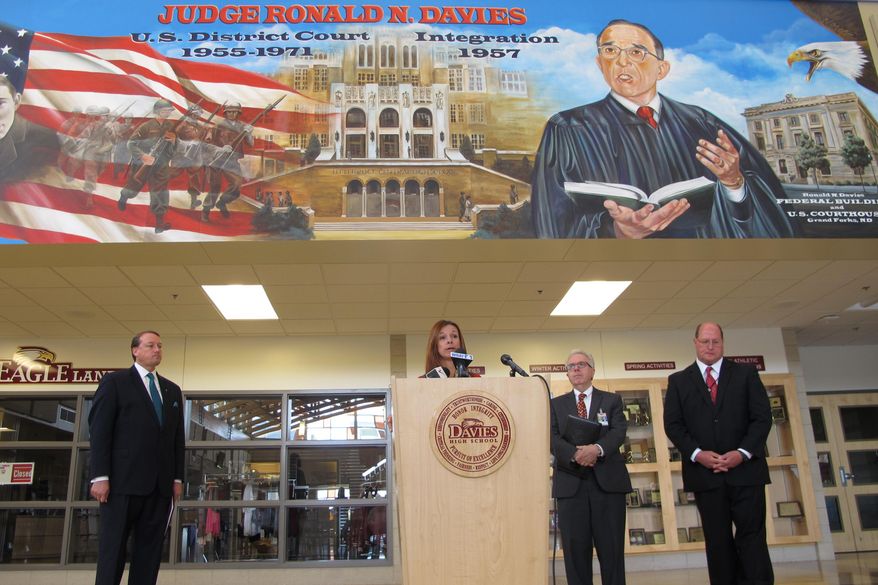 North Dakota Superintendent of Public Instruction Kirsten Baesler speaks about teacher training below a mural on the wall of Davies High School in Fargo, N.D., on Wednesday, July 15, 2015. Joining Baesler were from left, Marcus Lingenfelter, a vice president for the National Math and Science Initiative; David Flowers, West Fargo superintendent of schools; and Jeff Schatz, superintendent of Fargo public schools. (AP Photo/Dave Kolpack)
