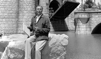 FILE - In this Sunday, July 17, 1955 file photo, Walt Disney sits on a rock in front of the Sleeping Beauty Castle in the Fantasyland section of Disneyland on opening day of the amusement theme park in Anaheim, Calif. A year earlier, Disney made his move. He succumbed to the lure of television and arranged to tie in the TV show (he hosted) with a Disneyland park. (AP Photo)
