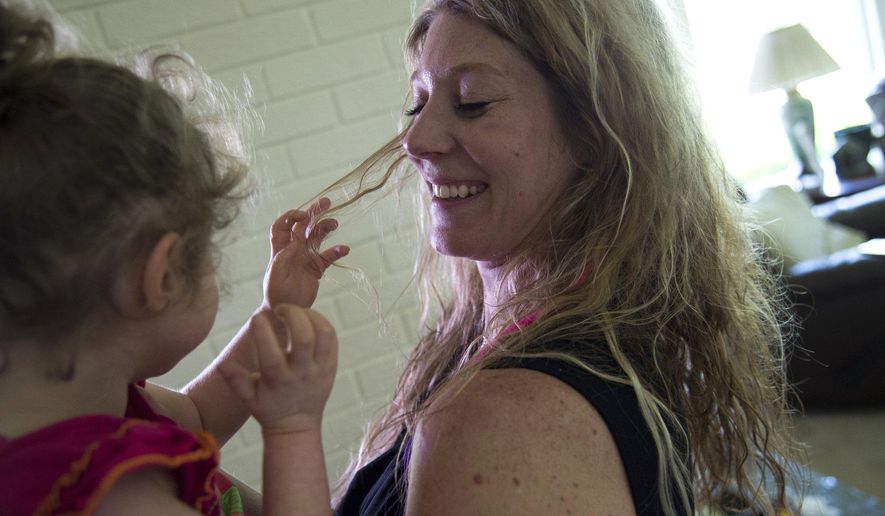 FOR USE SUNDAY, JULY 19, AND THEREAFTER - In this photo taken on Friday, June 26, 2015, Ida Chinonis and her daughter Bella laugh in their home in Grand Blanc, Mich. Bella, 6, suffers from seizures, and her mother says the only medication that helps her is a cannabis oil. (Zack Wittman/The Flint Journal-MLive.com via AP) LOCAL TELEVISION OUT; LOCAL INTERNET OUT; MANDATORY CREDIT