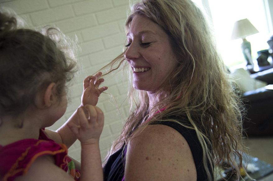 FOR USE SUNDAY, JULY 19, AND THEREAFTER - In this photo taken on Friday, June 26, 2015, Ida Chinonis and her daughter Bella laugh in their home in Grand Blanc, Mich. Bella, 6, suffers from seizures, and her mother says the only medication that helps her is a cannabis oil. (Zack Wittman/The Flint Journal-MLive.com via AP) LOCAL TELEVISION OUT; LOCAL INTERNET OUT; MANDATORY CREDIT