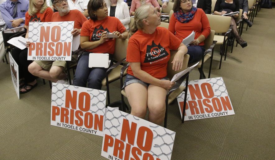 People look on during the prison relocation commission meeting as Utah lawmakers discuss a plan to move the state prison Thursday, July 16, 2015, in Salt Lake City. The lawmakers are hitting the breaks on their search for a new prison site, saying they need two more months to review technical details of each of their final four sites. (AP Photo/Rick Bowmer)