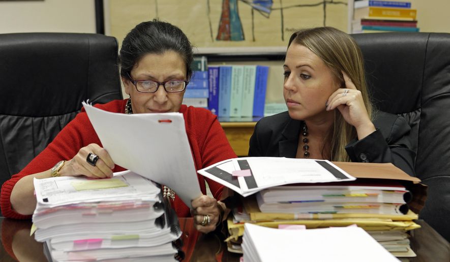 In this photo taken July 16, 2015, attorneys Grisel Ybarra, left, and Monica Barba Neumann look over documents at their office in Miami. Ybarra and Neumann represent several clients who could face deportation. With the US and Cuba inching closer to fully restoring diplomatic ties, including re-opening embassies for the first time in 54 years, the future is murky for tens of thousands of Cuban immigrants who have been ordered by immigration authorities to leave the country. As many as 25,000 immigrants who have outstanding deportation orders live in the U.S. legally but are considered priorities for immigration enforcement agents, according to data maintained by Immigration and Customs Enforcement. Those priorities include people with serious criminal convictions or who pose a threat to national security. (AP Photo/Alan Diaz)