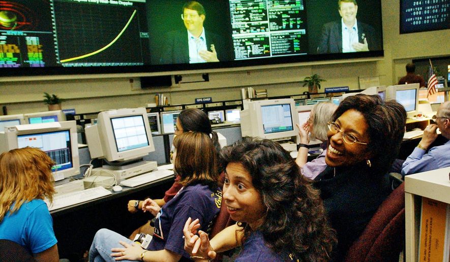 FILE - In this Sept. 21, 2003, file photo, Claudia Alexander, right, project manager for Galileo, waits in the mission control room in Pasadena, Calif., along with engineer Nagin Cox, center, and others for the spacecraft to take its final plunge into Jupiter. Alexander, a pioneering scientist who helped direct NASA's Galileo mission to Jupiter and the international Rosetta space exploration project, has died Saturday, July 11, 2015, after a long battle with breast cancer. She was 56. (AP Photo/Ric Francis, File)