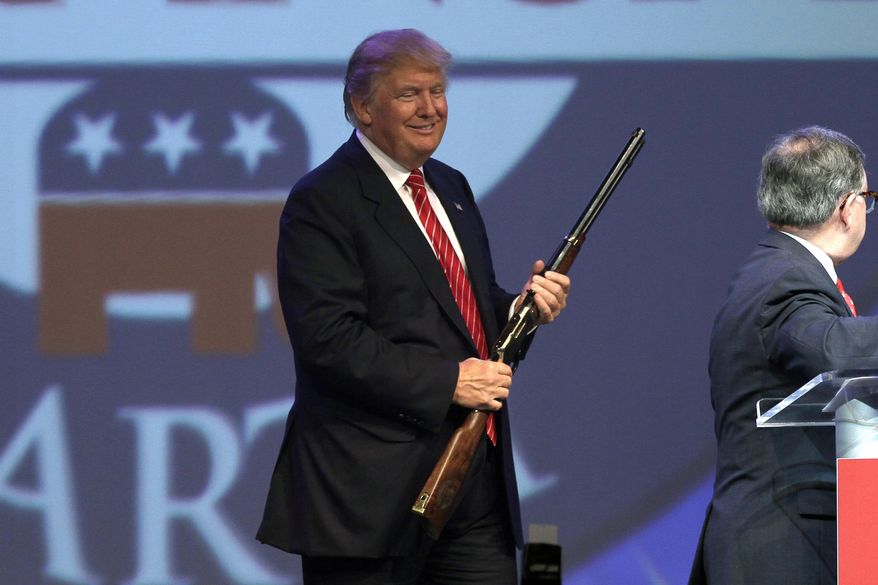 Republican presidential hopeful Donald Trump holds a Henry repeating rifle that was presented to him after speaking at the Republican Party of Arkansas Reagan Rockefeller dinner in Hot Springs, Ark., Friday, July 17, 2015. (AP Photo/Danny Johnston)