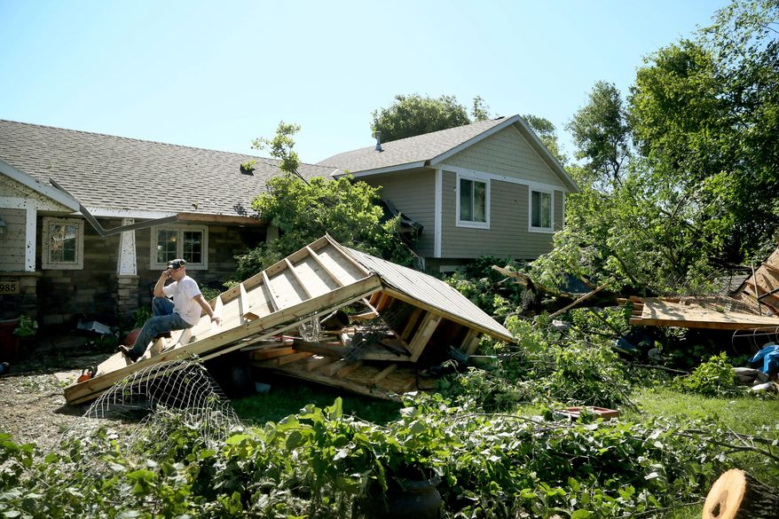 Jason Bogema sits atop a destroyed building on his property in Hollywood Township, where an EF1 tornado with 105 mph winds touched down Saturday, July 18, 2015, near Watertown, Minn. An EF1 tornado touched down near Watertown west of the Twin Cities overnight, damaging buildings and flipping cars but caused no injuries, the National Weather Service said Saturday. (David Joles/Star Tribune via AP) MANDATORY CREDIT; ST. PAUL PIONEER PRESS OUT; MAGS OUT; TWIN CITIES LOCAL TELEVISION OUT