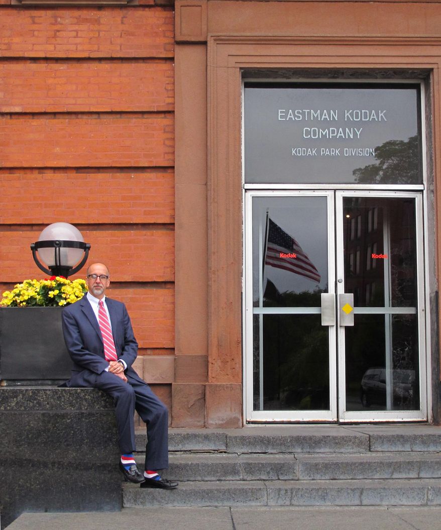 In this July 15, 2015 photo, Michael Alt, director of Eastman Business Park, sits outside the building in Rochester, N.Y., that housed Kodak founder George Eastman's office. Kodak considered selling its 1,250-acre business park to a smaller company after emerging from bankruptcy, but has instead been courting new businesses to the site, with the promise of access to plentiful utilities, infrastructure and Kodak's specialty technical and industrial capabilities. (AP Photo/Carolyn Thompson)