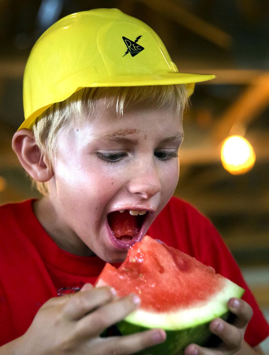FOR USE ON SUNDAY, JULY 19, 2015 - In this photo taken on Thursday, July 9, 2015, Chancellor Carneal, 8, of Caroline, competes in the watermelon eating contest at the Caroline County Agricultural Fair in Ruther Glen, Va. (Sarah Ann Jump/The Free Lance-Star via AP) MANDATORY CREDIT
