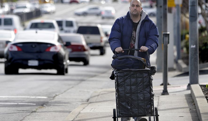 FILE - In this Feb. 11, 2015 file photo, Medi-Cal patient Richard Olivares, pushes his cart of belongings along a street in Sacramento Calif. California has enrolled 2.3 million people, nearly three times more than anticipated, under an optional expansion of the state's medicaid program. Coupled with higher than expected enrollment, Medi-Cal is now putting financial pressure on the state that was quick to embrace President Barack Obama's health care initiative.(AP Photo/Rich Pedroncelli, File)
