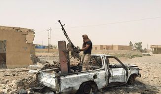 A militiaman allied with the Iraqi security forces dismantles a weapon from a destroyed vehicle belonging to the Islamic State group following a U.S.-led coalition airstrike against IS positions in southern Ramadi, Anbar province, Iraq, Monday, July 20, 2015. Iraqi security officials said that militants from the Islamic State group blew up a sports stadium near the militant-held city of Ramadi. (AP Photo) ** FILE **