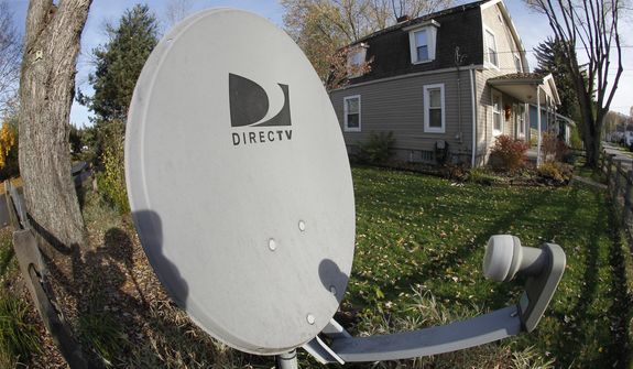This Nov. 2, 2011, file photo shows a DirecTV satellite dish on a post in the front yard of a home in Harmony, Pa. (AP Photo/Keith Srakocic, File)