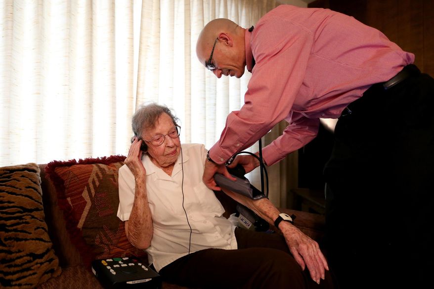 ADVANCE FOR SUNDAY JULY 26 AND THEREAFTER - In a Friday, July 10, 2015 photo, Mary Venturacci, 98, has her blood pressure checked by Marty Surface, a nurse practitioner with Kaiser Permanente, in her home in in Salem, Ore.. House calls are gaining recognition for their effectiveness in lowering costs and improving outcomes for the most fragile, complex, and, in turn, most costly health care consumers. (Anna Reed/Statesman-Journal via AP) MANDATORY CREDIT