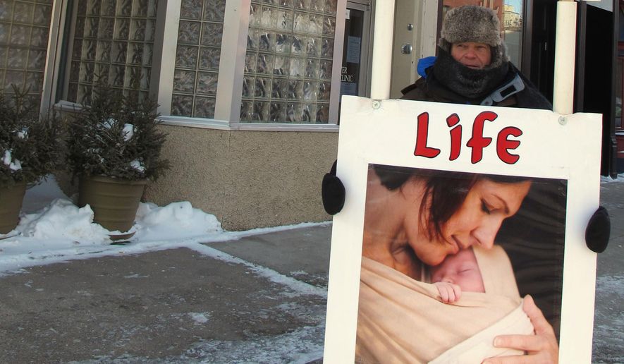 An abortion protester stands outside the Red River Women&#39;s Clinic in Fargo, N.D., on Feb. 20, 2013. (Associated Press)