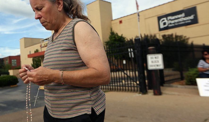 In this undated file photo, a Missouri woman takes part in a pro-life rally outside a Planned Parenthood building in St. Louis. On Feb. 27, 2019, the Republican-controlled Missouri House of Representatives passed a bill that would ban almost all abortions if the U.S. Supreme Court were to overturn Roe v. Wade.
(Associated Press) **FILE**