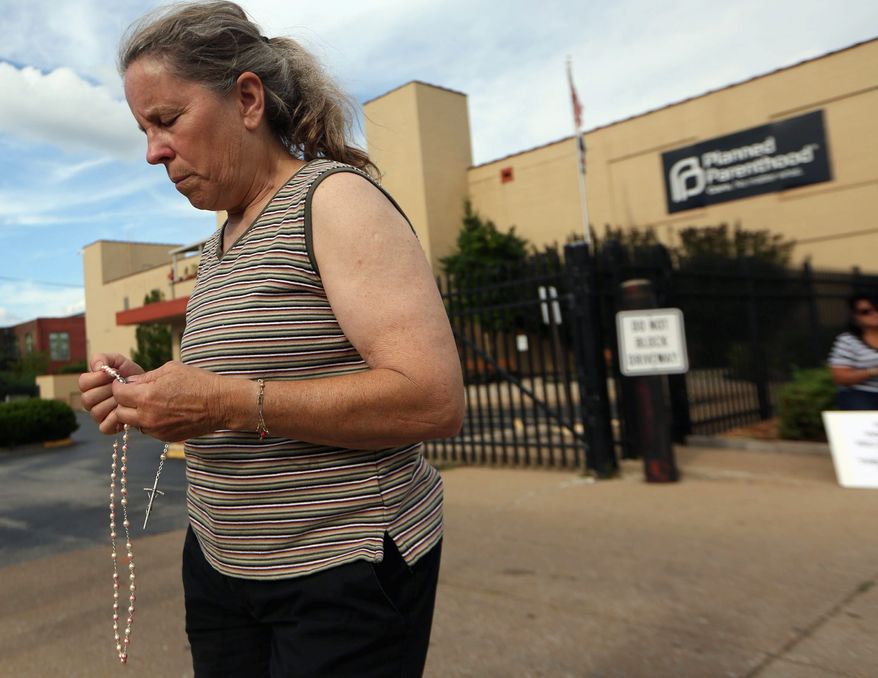 In this undated file photo, a Missouri woman takes part in a pro-life rally outside a Planned Parenthood building in St. Louis. On Feb. 27, 2019, the Republican-controlled Missouri House of Representatives passed a bill that would ban almost all abortions if the U.S. Supreme Court were to overturn Roe v. Wade.
(Associated Press) **FILE**