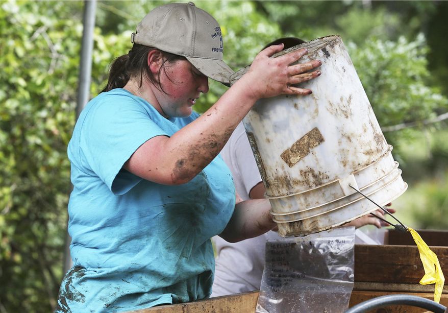 FOR USE SUNDAY, JULY 26, 2015 - In this photo taken on June 23, 2015, Amanda McMahon pours out excavated soil to be washed as archaeological researchers continue to dig at a site near Salado, Texas, on Buttermilk Creek where they they have previously unearthed artifacts which they say are 15,000 years old. (Tom Reel/The San Antonio Express-News via AP) RUMBO DE SAN ANTONIO OUT; NO SALES; MANDATORY CREDIT