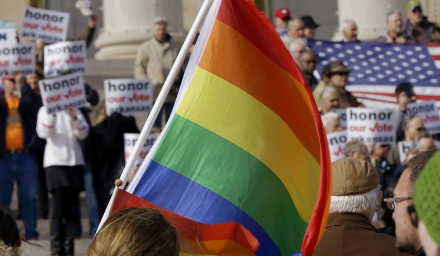 In this file photo taken  Nov. 19, 2014, supporters of Arkansas&#39; law banning same sex marriage, top, hold a rally as a protestor waves a rainbow flag at the Arkansas state Capitol in Little Rock, Ark. The Arkansas Supreme Court voted on a narrow part of the state&#39;s case over gay marriage in June, 2015, but only planned on issuing that decision if the nation&#39;s highest court didn&#39;t legalize same-sex marriage, a justice said Thursday, July 23, 2015. (AP Photo/Danny Johnston, File)