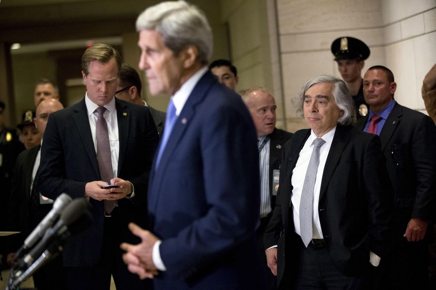 Secretary of State John Kerry, accompanied by Secretary of Energy Ernest Moniz, third from right, gives brief remarks to members of the media before attending a classified briefing for all House members on Capitol Hill, in Washington, Wednesday, July 22, 2015, to speak about the deal reached to curb Iran's nuclear program in exchange for billions of dollars in relief from international sanctions. (AP Photo/Andrew Harnik)